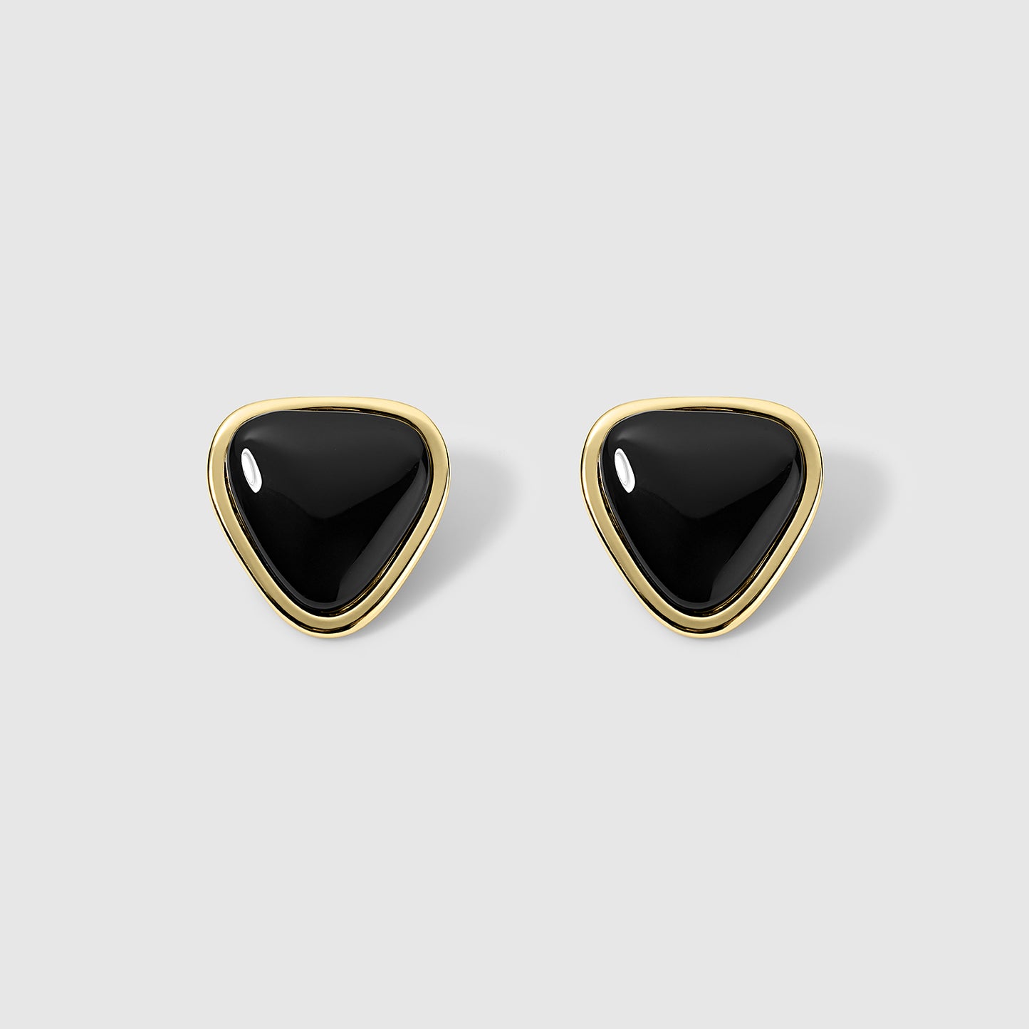Pair of onyx stud earrings with a teardrop-shaped design framed in a polished gold metal setting, displayed on a light gray background. Sleek and modern, ideal for both casual and formal occasions.