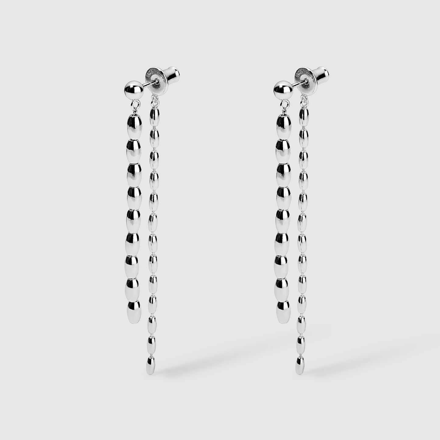Pair of silver drop earrings with polished, graduated oval beads forming a sleek, elongated chain design, displayed on a light gray background. Lightweight and elegant, perfect for formal or casual occasions.